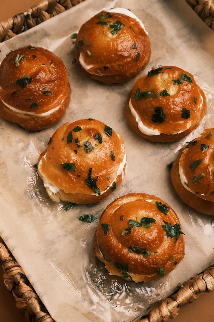 Freshly baked artisan rolls topped with herbs and creamy filling for a cozy, gourmet snack.